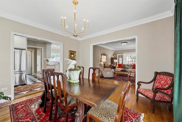 dining space with crown molding, wood finished floors, and a chandelier