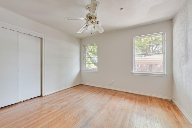 unfurnished bedroom with baseboards, a ceiling fan, light wood finished floors, and a closet