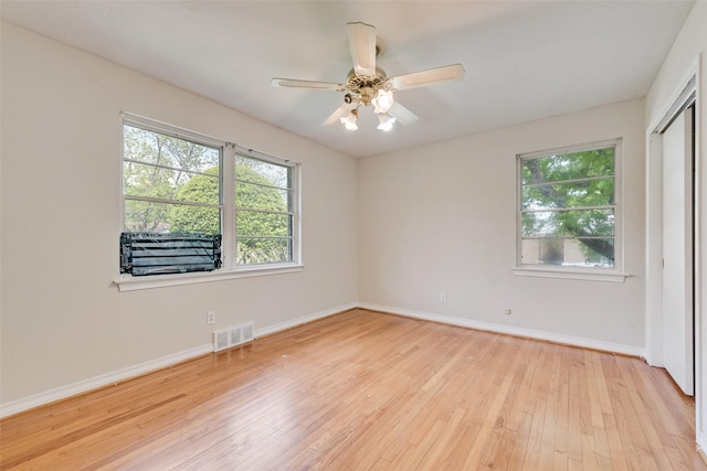 spare room with baseboards, a healthy amount of sunlight, light wood finished floors, and visible vents