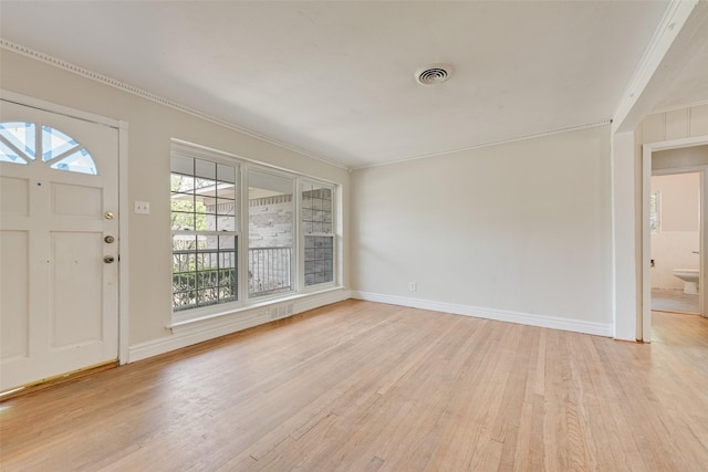 entrance foyer featuring light wood-type flooring, baseboards, crown molding, and visible vents