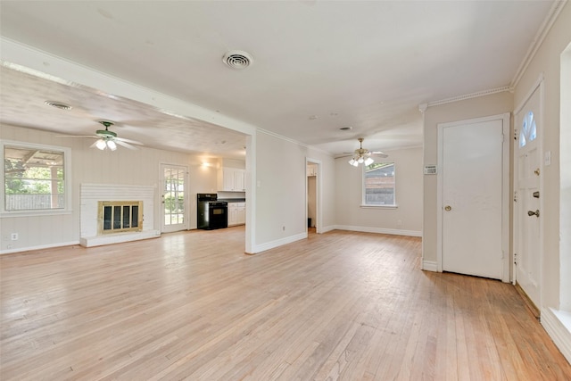 unfurnished living room featuring ornamental molding, light wood-style flooring, visible vents, and ceiling fan