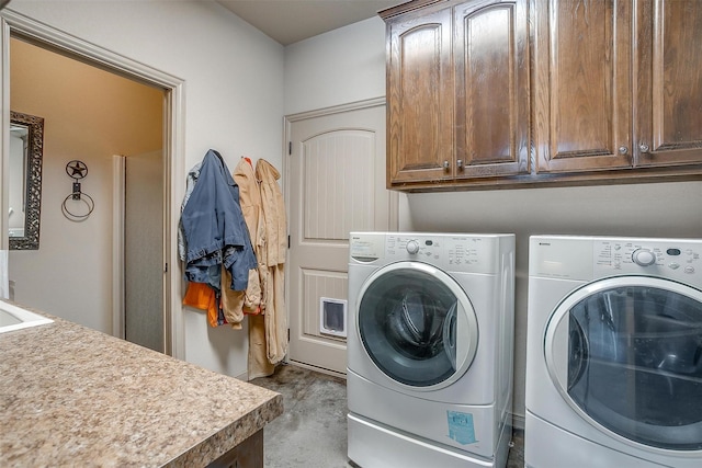 laundry room with independent washer and dryer and cabinet space