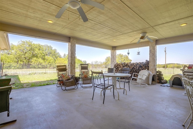 view of patio featuring outdoor dining space, ceiling fan, and fence