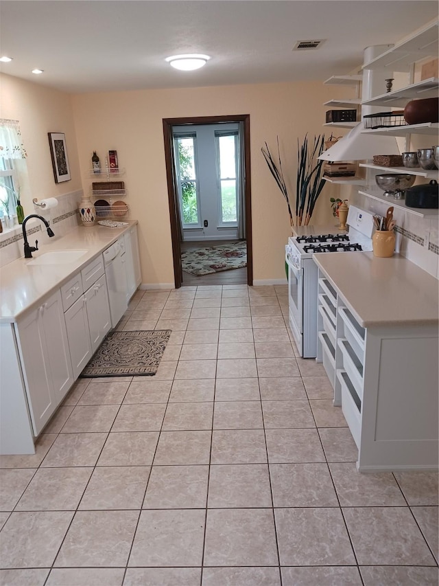 1806 Elm Crest Dr, Arlington, TX 76012 - kitchen with white appliances, a sink, white cabinets, light tile patterned flooring, and light countertops