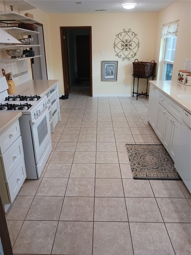 1806 Elm Crest Dr, Arlington, TX 76012 - kitchen featuring white range with gas cooktop, light tile patterned floors, white cabinets, and light countertops