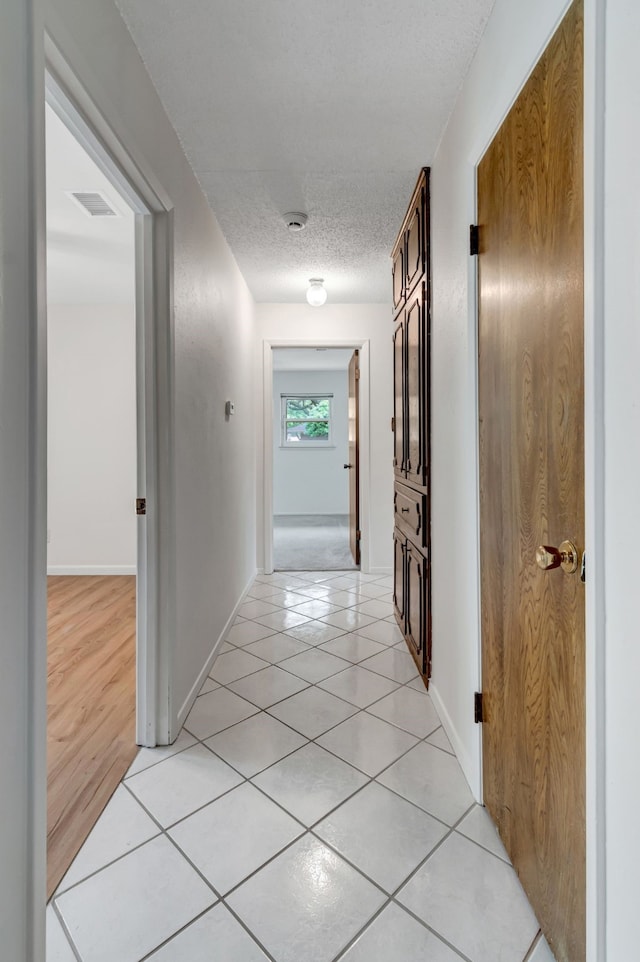 1806 Elm Crest Dr, Arlington, TX 76012 - hall featuring a textured ceiling, light tile patterned flooring, and baseboards