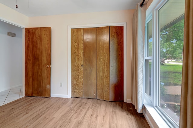 1806 Elm Crest Dr, Arlington, TX 76012 - unfurnished bedroom featuring multiple windows, wood finished floors, a closet, and baseboards