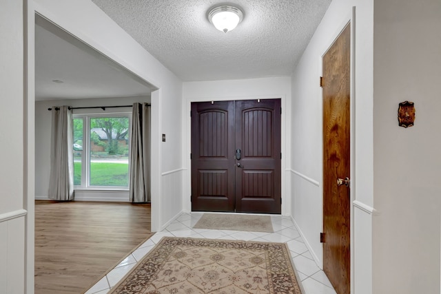 1806 Elm Crest Dr, Arlington, TX 76012 - entryway featuring a textured ceiling, light tile patterned floors, and baseboards