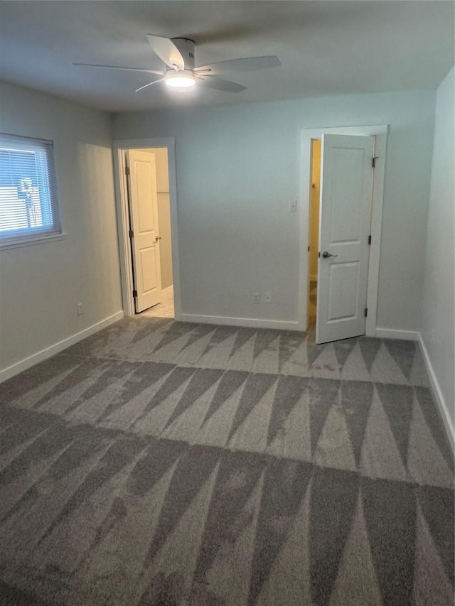 carpeted spare room with baseboards and a ceiling fan