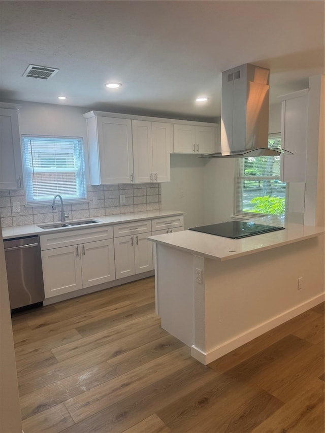 kitchen featuring island range hood, visible vents, dishwasher, a sink, and decorative backsplash