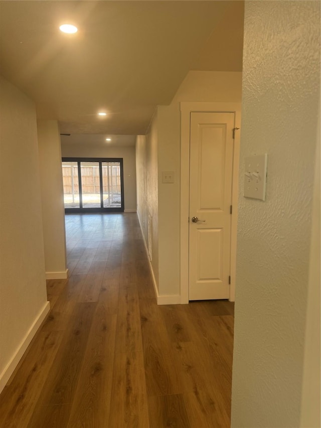 hallway featuring baseboards, dark wood-style floors, and recessed lighting