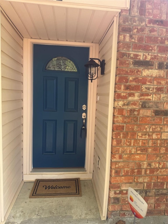 entrance to property featuring brick siding