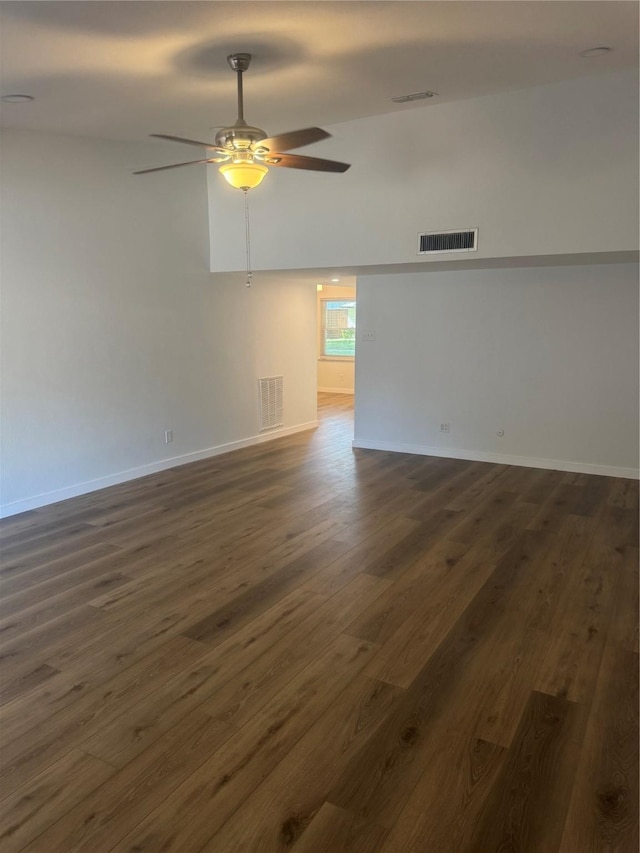 unfurnished room featuring visible vents, baseboards, a ceiling fan, and dark wood finished floors