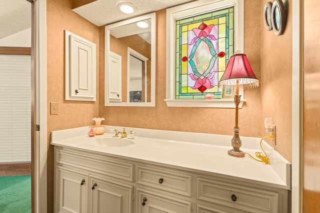 bathroom featuring a textured wall and vanity