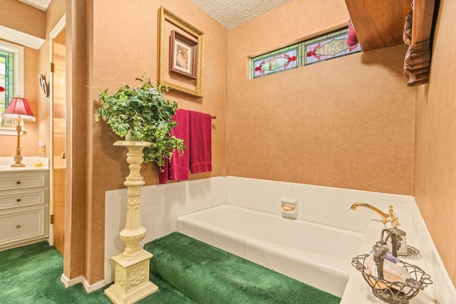 bathroom featuring a garden tub and vanity