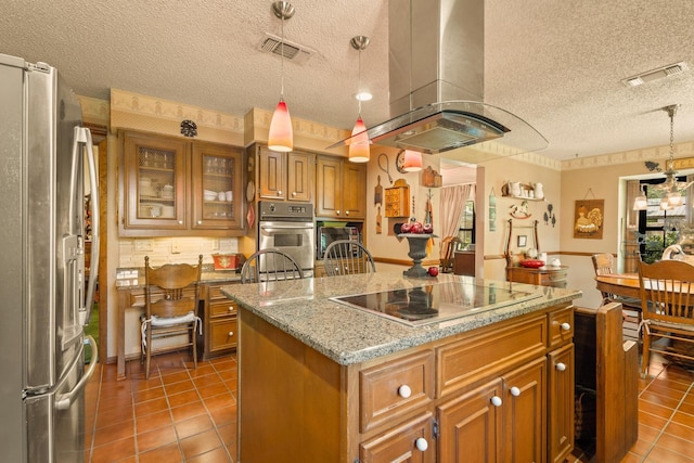 kitchen featuring a textured ceiling, island range hood, stainless steel appliances, visible vents, and a kitchen island