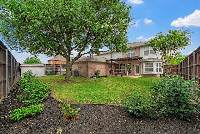 back of property featuring a fenced backyard, brick siding, and central AC unit
