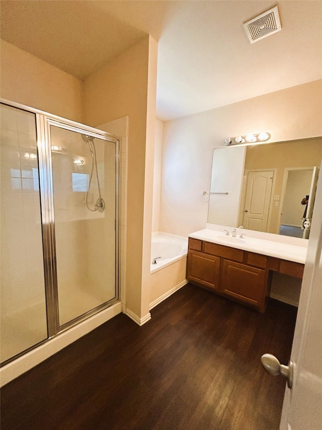 4303 Grassy Glen Dr, Corinth, TX 76208 - bathroom featuring wood finished floors, vanity, a shower stall, and a garden tub