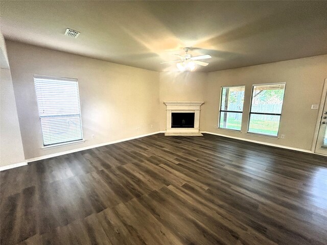 4303 Grassy Glen Dr, Corinth, TX 76208 - unfurnished living room with a ceiling fan, dark wood-style floors, and a fireplace with raised hearth