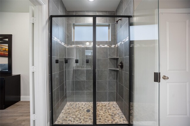 full bathroom with a shower stall and baseboards