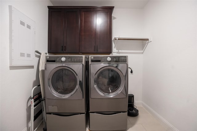 laundry area featuring cabinet space, tile patterned floors, baseboards, and separate washer and dryer