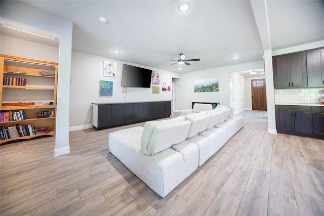living room with light wood finished floors, a ceiling fan, baseboards, and recessed lighting