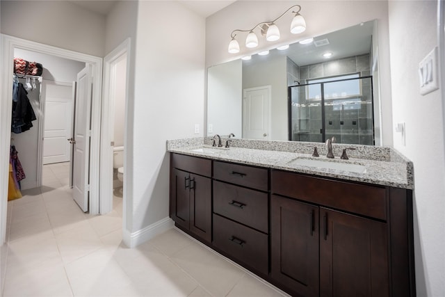 full bath with toilet, a sink, double vanity, and a stall shower