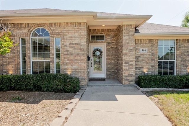 property entrance with brick siding and roof with shingles