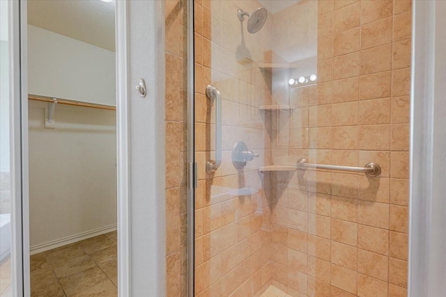 full bathroom with a walk in closet and a stall shower