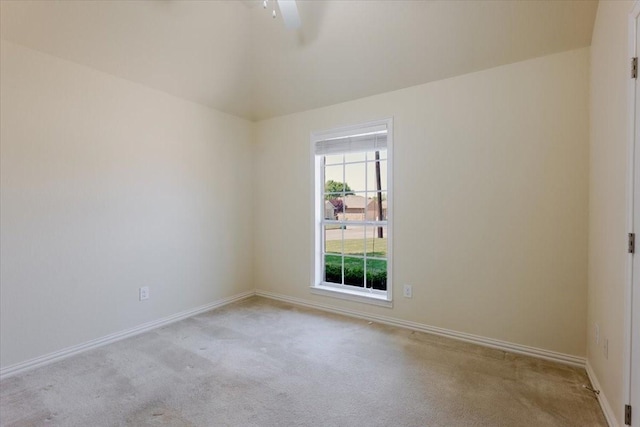 empty room featuring baseboards, a ceiling fan, and light colored carpet
