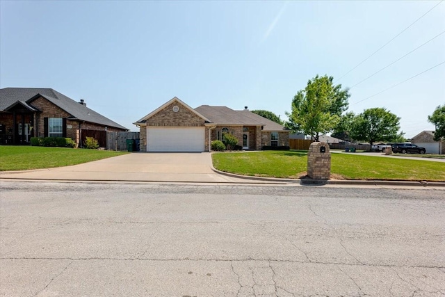 ranch-style home with fence, a front lawn, an attached garage, driveway, and stone siding