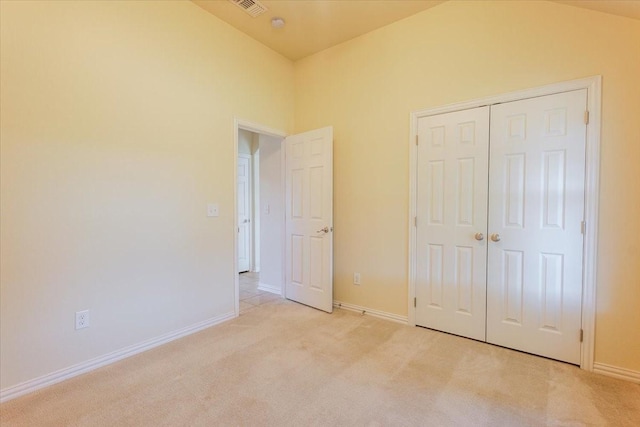 unfurnished bedroom with light colored carpet, baseboards, and a closet