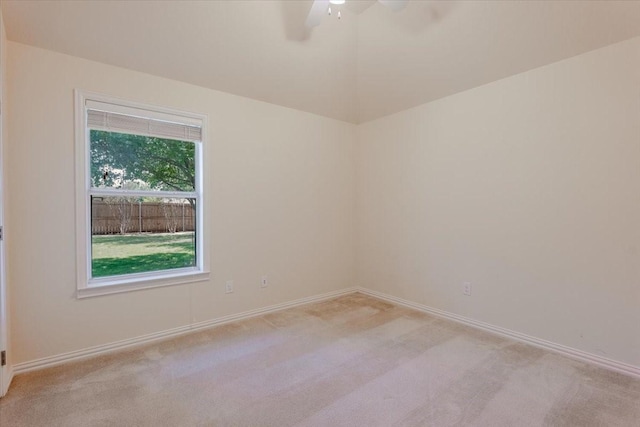 unfurnished room with light carpet, a ceiling fan, and baseboards