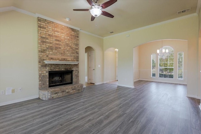 unfurnished living room with arched walkways, visible vents, ceiling fan with notable chandelier, wood finished floors, and a brick fireplace