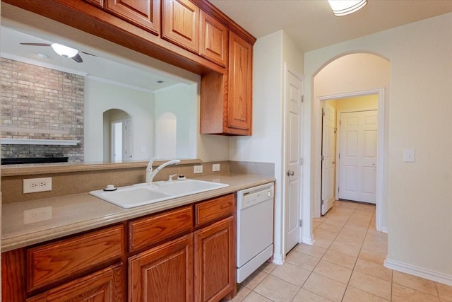 kitchen with white dishwasher, a sink, brown cabinetry, light tile patterned floors, and arched walkways