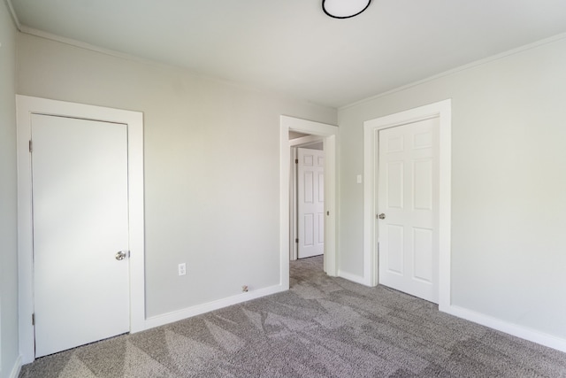unfurnished bedroom featuring carpet floors, ornamental molding, and baseboards