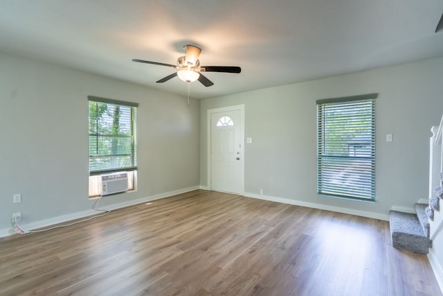 entryway with stairway, wood finished floors, a ceiling fan, cooling unit, and baseboards