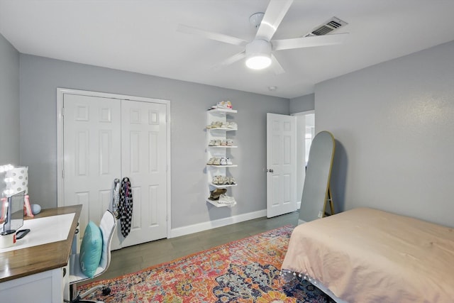 bedroom with a ceiling fan, wood finished floors, a closet, baseboards, and visible vents