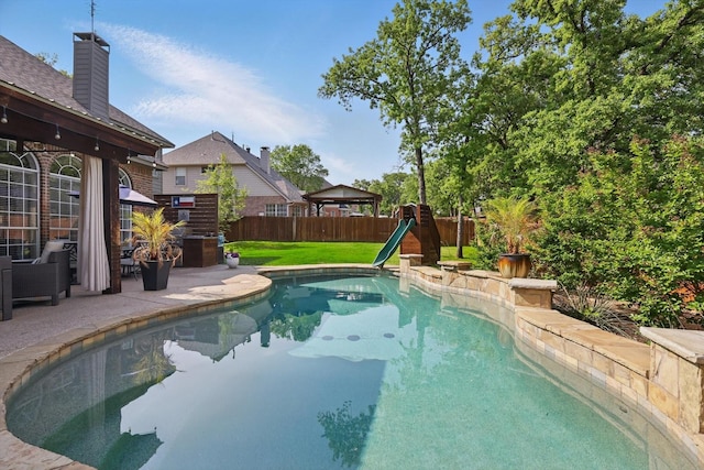 view of swimming pool with a yard, a fenced in pool, a patio, and a fenced backyard
