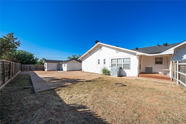 602 E Beauregard St, Rotan, TX 79546 - back of house featuring a fenced backyard, a storage shed, stucco siding, a patio area, and an outdoor structure