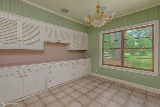 kitchen with light countertops, white cabinetry, a chandelier, and ornamental molding