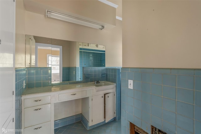 bathroom featuring tile walls, tile patterned flooring, vanity, and a wainscoted wall