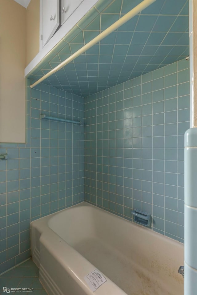 full bath featuring tub / shower combination and tile walls