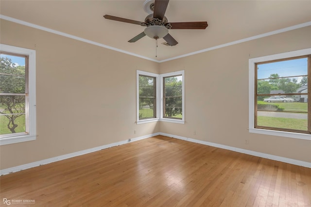 unfurnished room featuring baseboards, a healthy amount of sunlight, crown molding, and light wood-type flooring