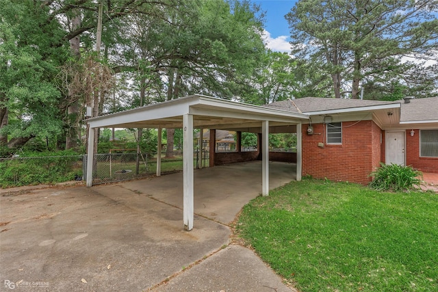 view of parking featuring an attached carport, concrete driveway, and fence