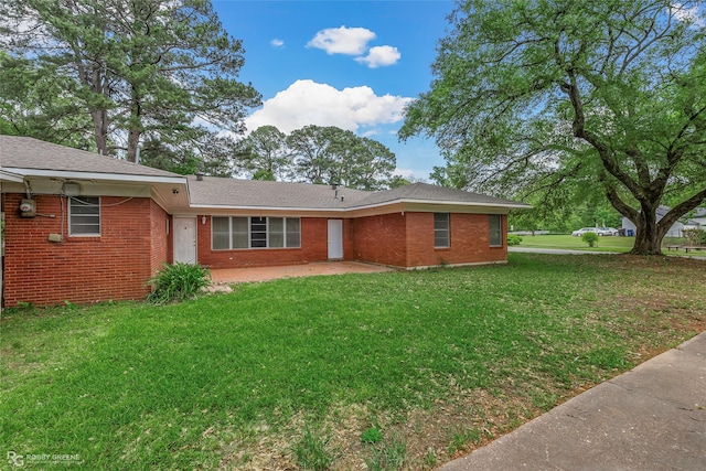 rear view of property featuring brick siding, a yard, and a patio area