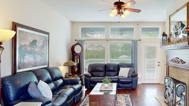living area featuring ceiling fan, wood finished floors, and a fireplace