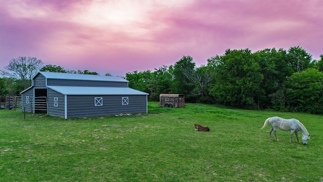 yard at dusk featuring an outbuilding