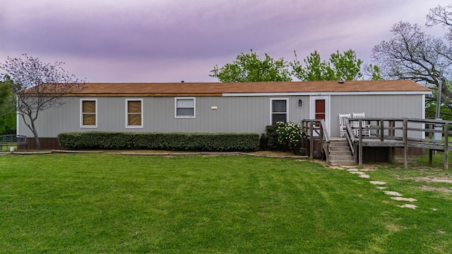 rear view of property featuring a yard and a deck