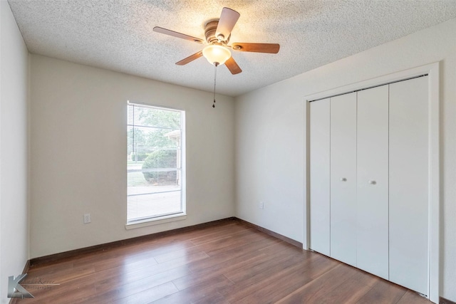 1026 Baylor St, Abilene, TX 79602 - unfurnished bedroom featuring a textured ceiling, a closet, a ceiling fan, and wood finished floors
